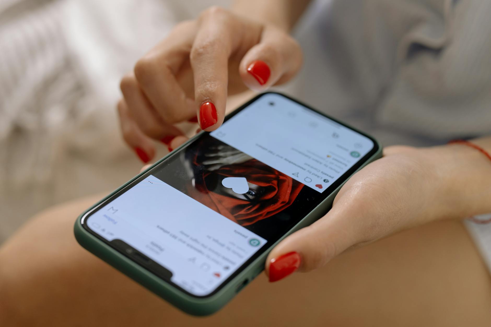 Porównywanie się z innymi w social mediach a nasze samopoczucie Kobieta z czerwonymi paznokciami przegląda social media na smartfonie